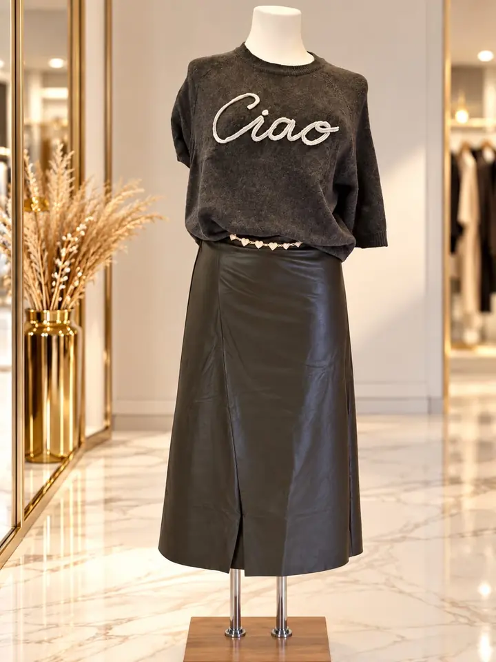 Anthrazitfarbenes Strickshirt mit cremefarbenem Schriftzug „Ciao“ zu schwarzem Midirock in Lederoptik mit Schlitz und Perlengürtel, Herbstmode 2026 im Mode-Atelier Völkl, Haar bei München