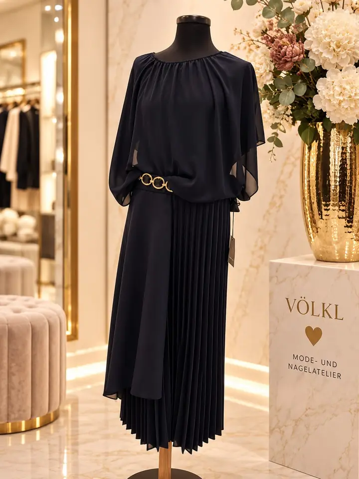 Fließendes Kleid in Nachtblau mit Chiffon-Oberteil, weiten Cape-Ärmeln, Plisseerock und goldfarbenem Ringgürtel, Herbstmode 2026 im Mode-Atelier Völkl, Haar bei München