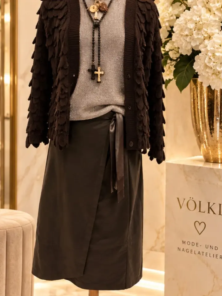 Dunkelbrauner Cardigan mit Schuppen-Strickstruktur über grau-beigem Pullover zu Wickelrock in dunklem Oliv mit Satinband, lange Ketten mit Kreuzanhängern, Herbstmode 2026 im Mode-Atelier Völkl, Haar bei München