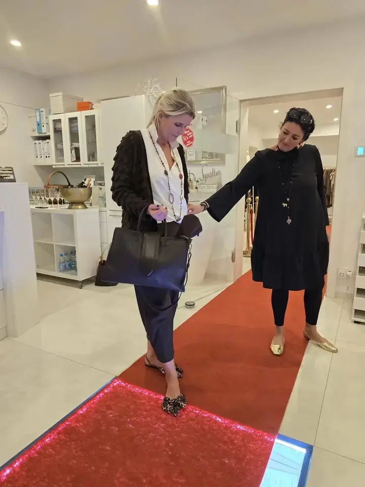Zwei Herbstlooks auf dem Laufsteg: weiße Bluse mit langer Kette und schwarzer Strickjacke, daneben ein schwarzes Kleid, Herbstmodenschau 2026 im Mode-Atelier Völkl