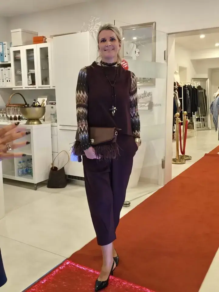 Strickjacke mit Zickzack-Muster, Culotte in Aubergine und Fransen-Clutch auf dem Laufsteg der Herbstmodenschau 2026 im Mode-Atelier Völkl, Haar bei München